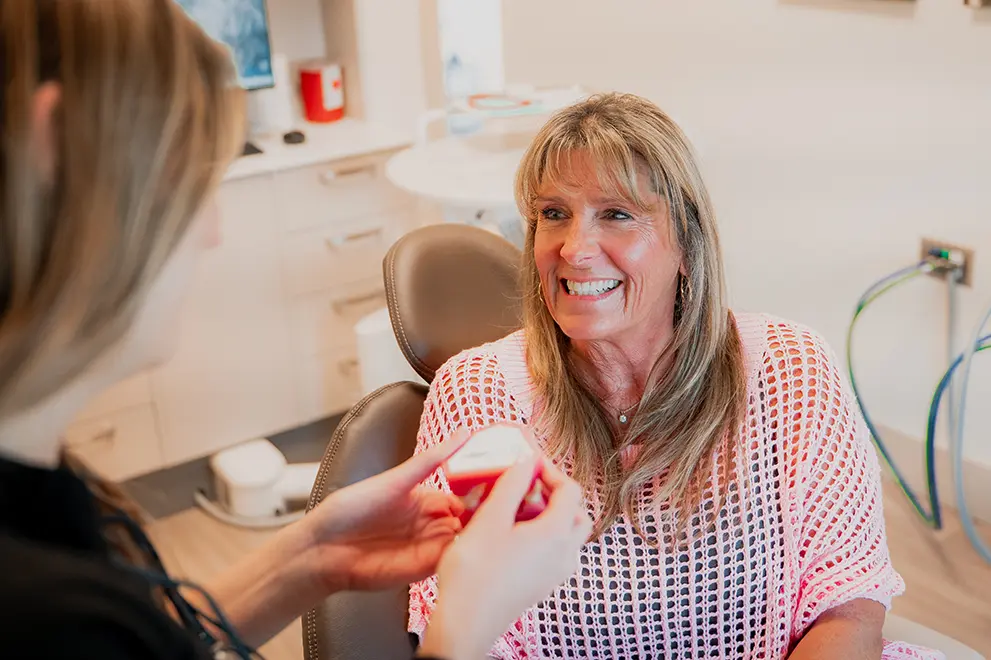Smiling patient being shown a model of teeth